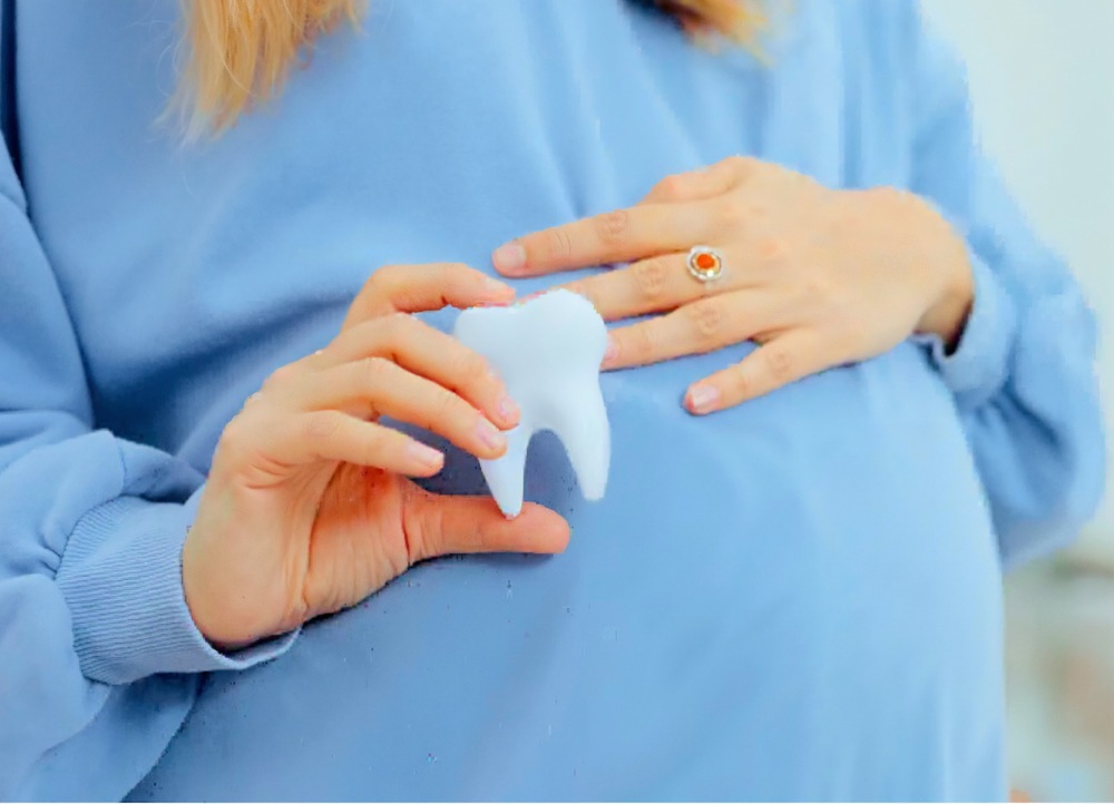 беременная девушка с макетом зуба